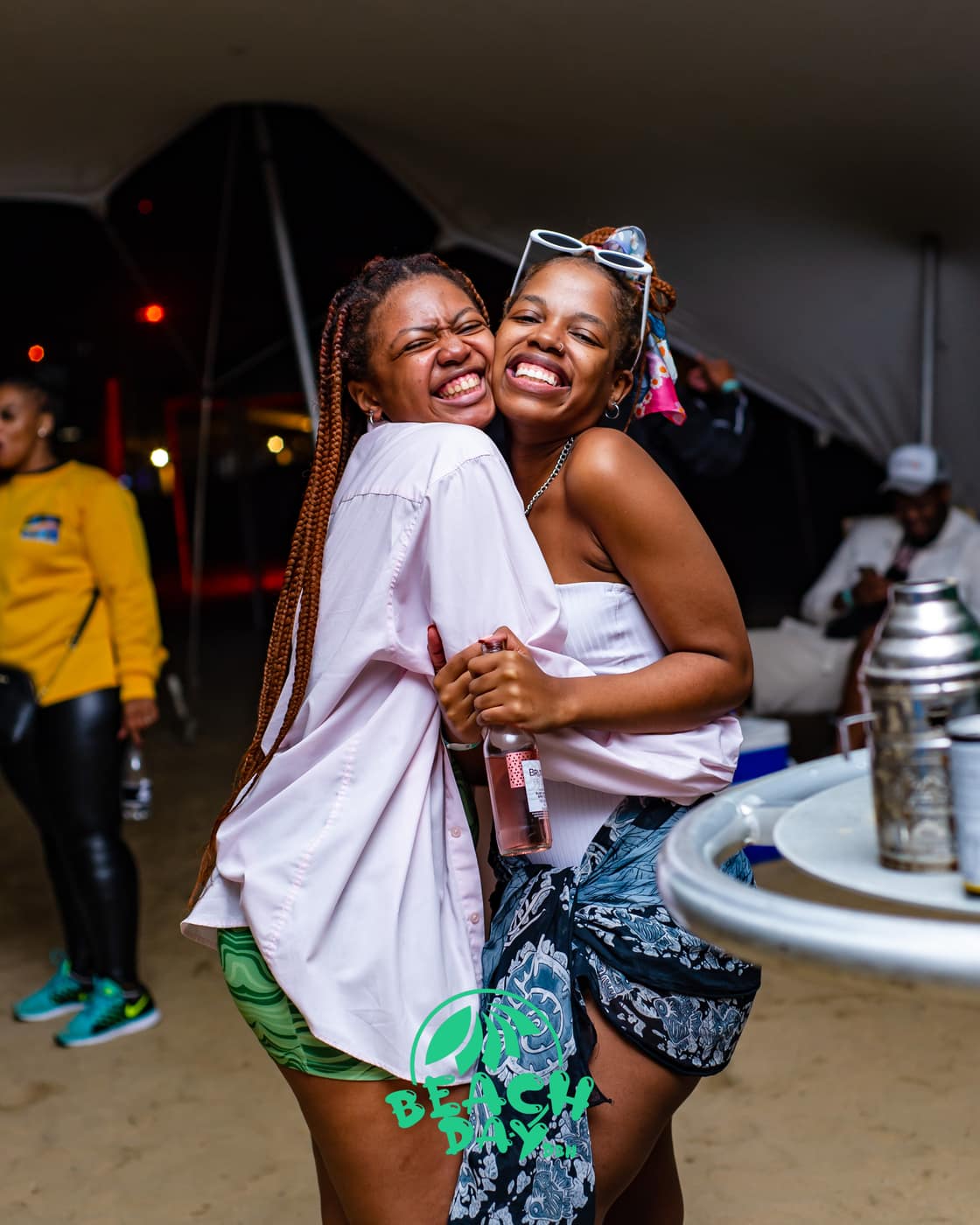 Two friends laughing and hugging at the event